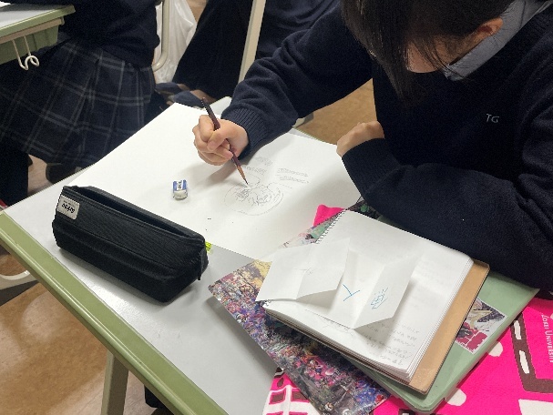 「分野説明会」での東京造形大学の模擬授業の様子 袋の中から紙を二つひき、その出会った言葉を色やかたちに置き換え描いています
