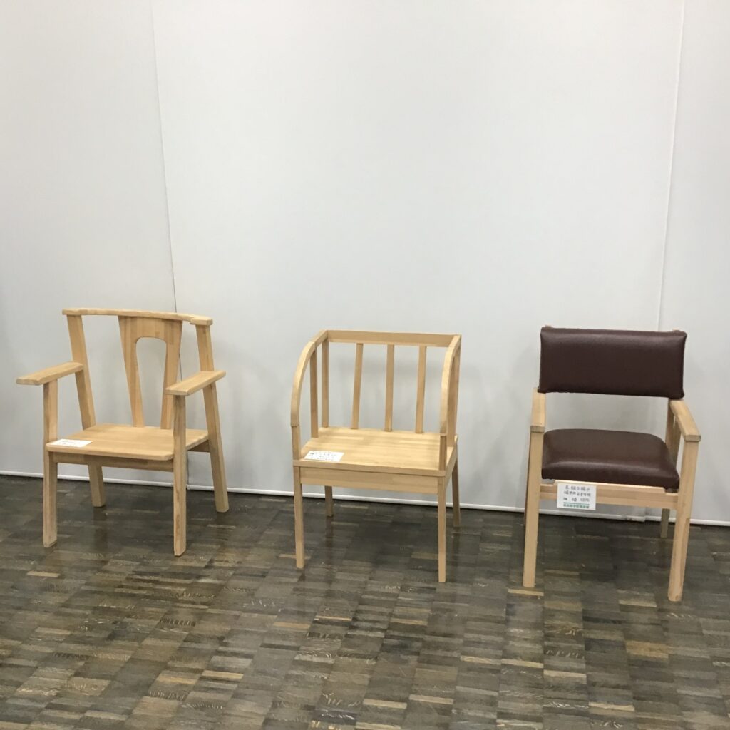 立体部門　木工作品 左から 3年　藤本沙笑　【NUKUMORI】 杉材　50×74×101㎝ 3年　小野征成　【弓状肘掛椅子】 杉材　47×50×86㎝ 3年　橘　旺佑　【高級な椅子】 杉材　50×54×81㎝